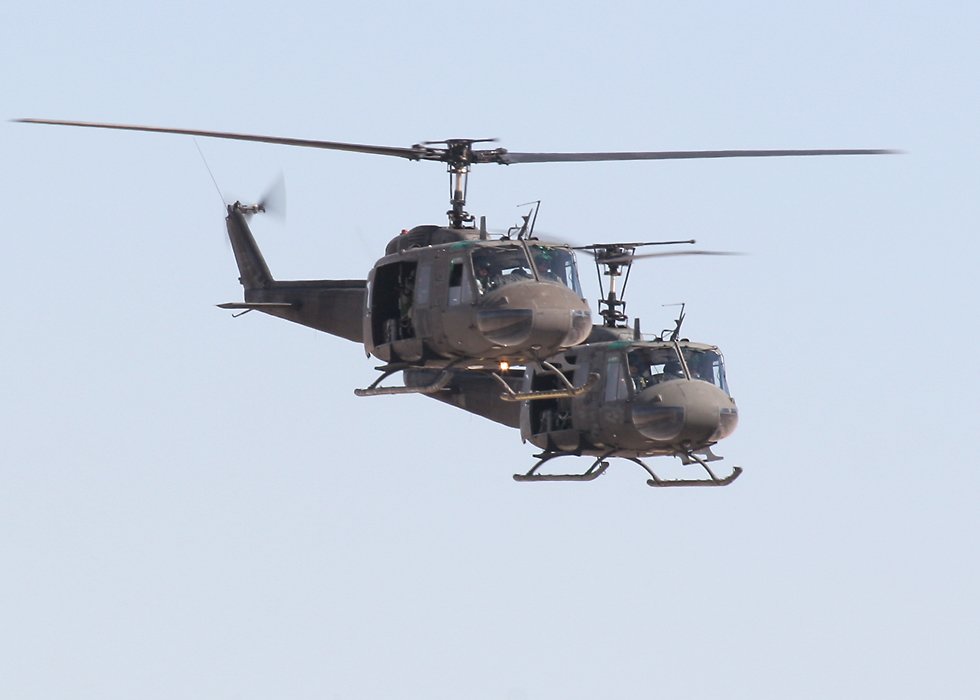 two UH-1 Iroquois helicopters in formation   (click here to open a new window with this photo in computer wallpaper format)