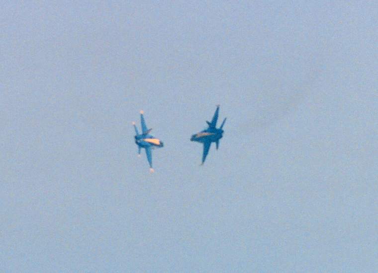 two Blue Angels banking in towards each other