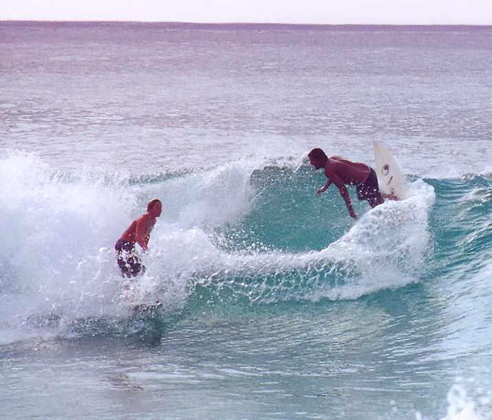 two surfers on the same wave eye each other
