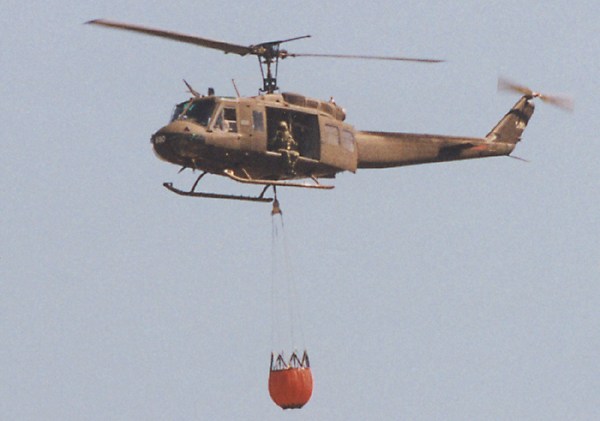 army Huey with monsoon bucket and guy hanging out the side