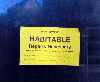government sticker on window saying 'Habitable, repairs necessary'